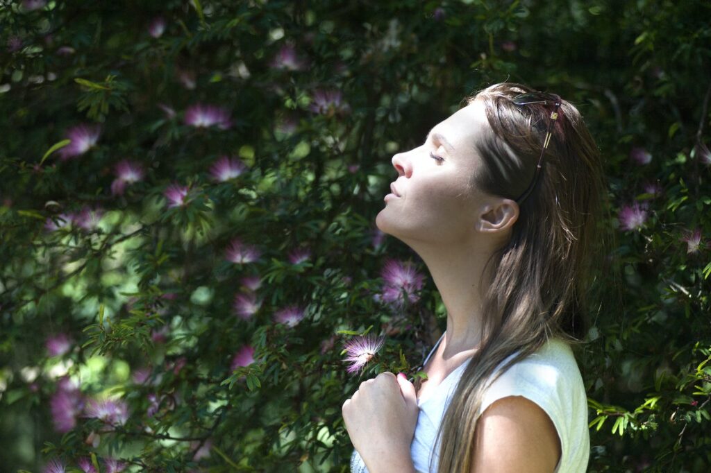 Respiraçãoi, Woman Closing Her Eyes Against Sun Light Standing Near Purple Petaled Flower Plant